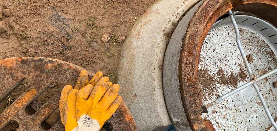 Neu eingebauter Gulli, daneben Arbeitshandschuhe
