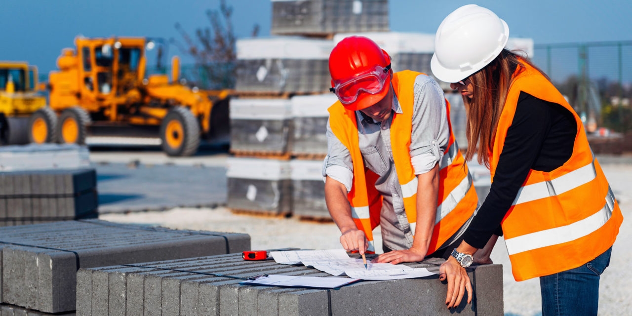 Zwei Bauarbeiter studieren den Bauplan