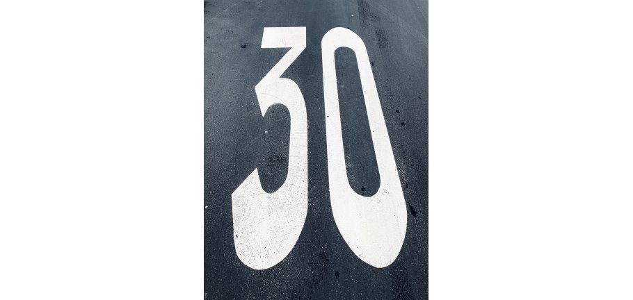 Tempo 30 Auf dem Foto sieht man eine auf die Straßenfahrbahn gemalte dreißig.