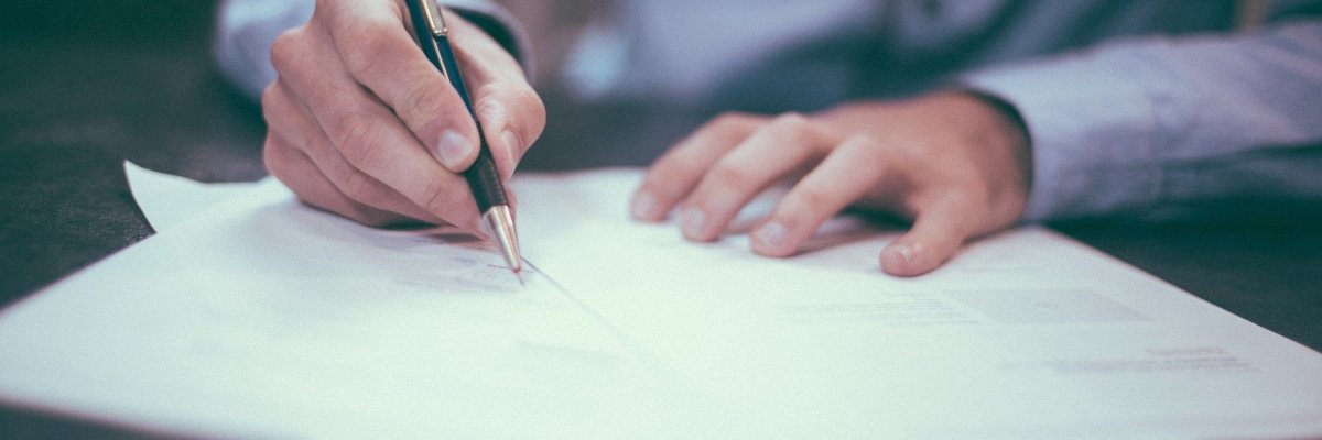 Mann schreibt auf Papier. Mann schreibt auf Papier.