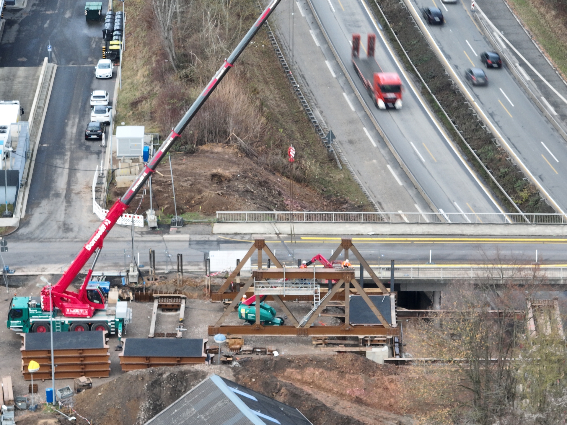 Bauarbeiter arbeiten an einer Brücke, die über eine Autobahn führt.