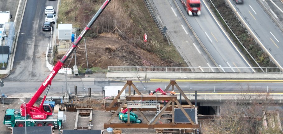 Bauarbeiter arbeiten an einer Brücke, die über eine Autobahn führt.