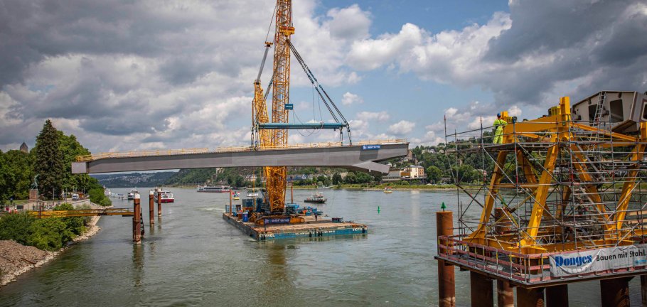Auf der Baustelle für den Neubau der Pfaffendorfer Brücke wurde das erste größere, rund 480 Tonnen schwere Stahlbauteil mit Präzisionsarbeit eingehoben. Auf der Baustelle für den Neubau der Pfaffendorfer Brücke wurde das erste größere, rund 480 Tonnen schwere Stahlbauteil mit Präzisionsarbeit eingehoben.