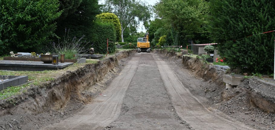 Ein tief ausgebaggerter Weg auf dem im Hintergrund der Bagger erkennbar ist.