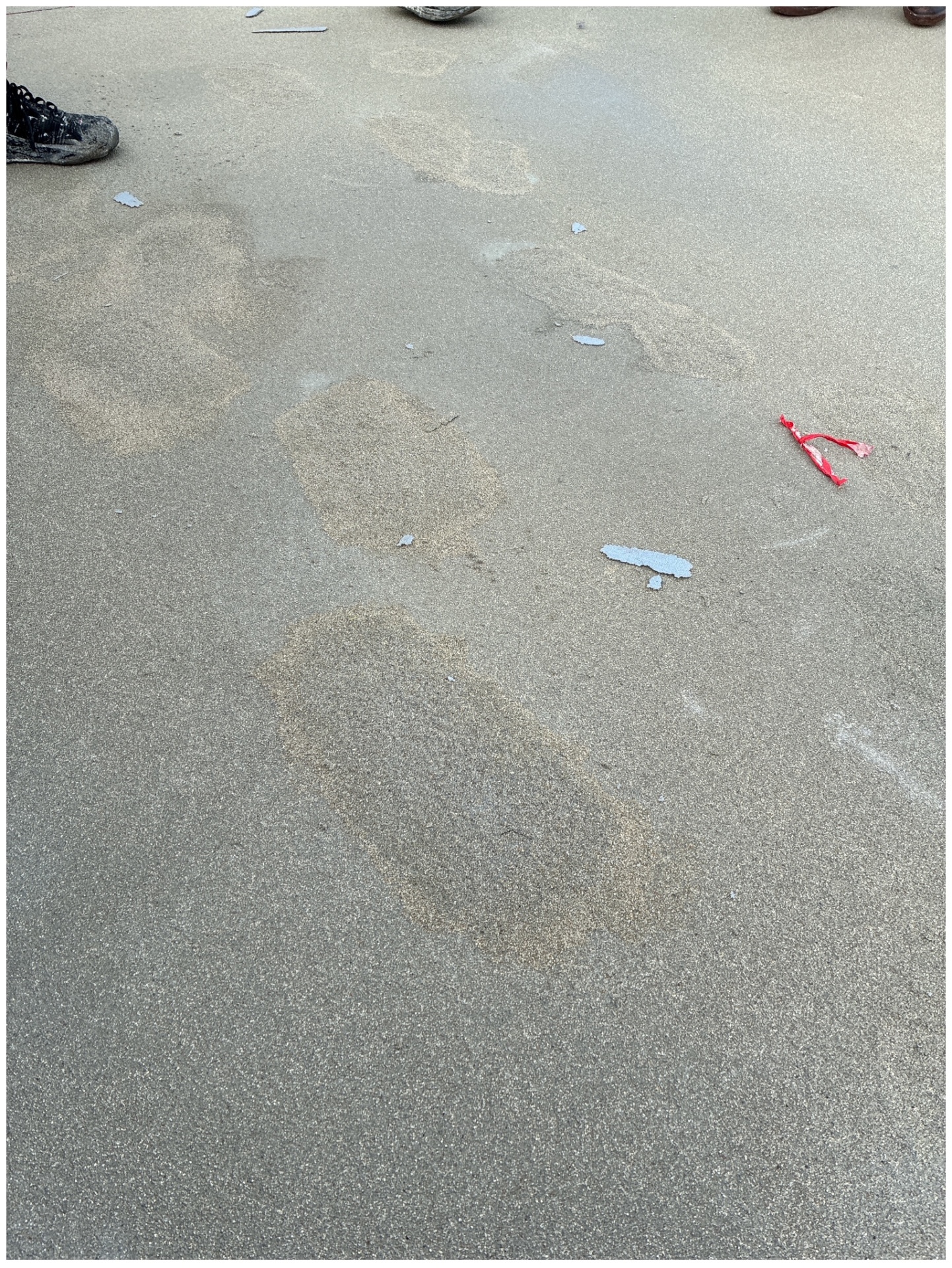 Schäden am vorhandene Belag. Fußspuren sind erkennbar. 