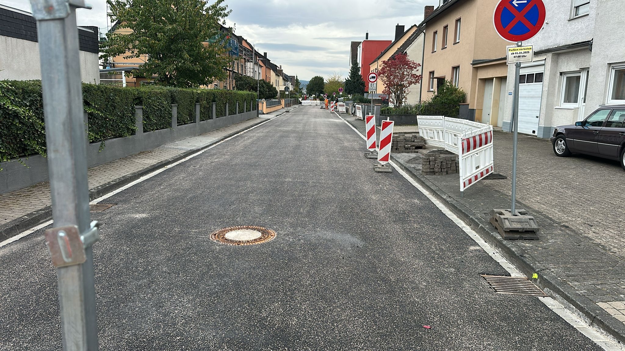 Eine fertiggestellte Straße mit noch einigen Bauzäunen im Hintergrund.