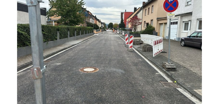 Eine fertiggestellte Straße mit noch einigen Bauzäunen im Hintergrund.