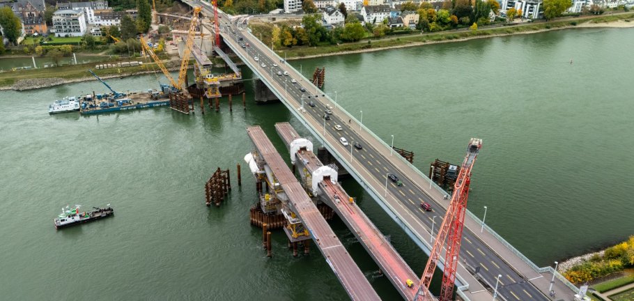 Aus der Vogelperspektive lässt sich bereits der Verlauf der neuen Pfaffendorfer Brücke in der Parallellage erkennen.  Aus der Vogelperspektive ist eine Brückenbaustelle im Rhein zu erkennen.