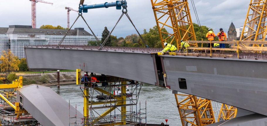 Für den Einhub der neuen Stahlbauteile war bei den beteiligten Unternehmen zentimetergenau Arbeit gefragt. Bauarbeiter arbeiten an einem Stahlbauteil.