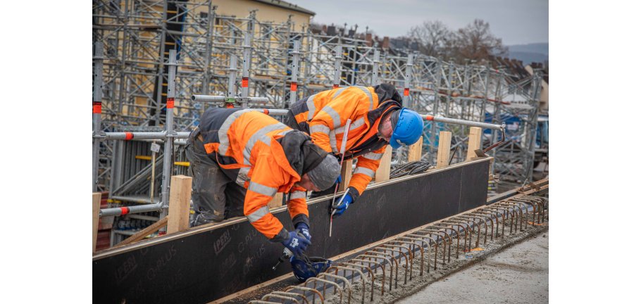 Zwei Bauarbeiter die an Schaltafeln arbeiten.