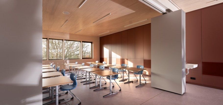 Sonnenlicht fällt durch Fenster in einen modernen Klassenraum ein.