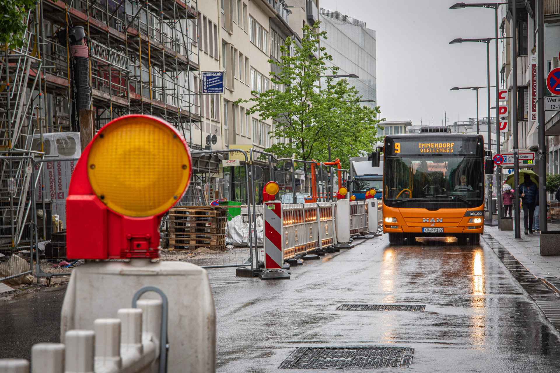 Ein Bus fährt an einer abgesperrten Baustelle vorbei. Ein Bus fährt an einer abgesperrten Baustelle vorbei.