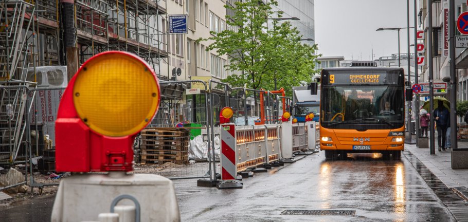 Ein Bus fährt an einer abgesperrten Baustelle vorbei.