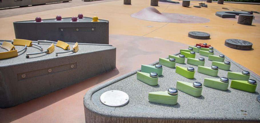 Spielgeräte stehen auf einem Wasserspielplatz, ohne, dass Wasser fließt.