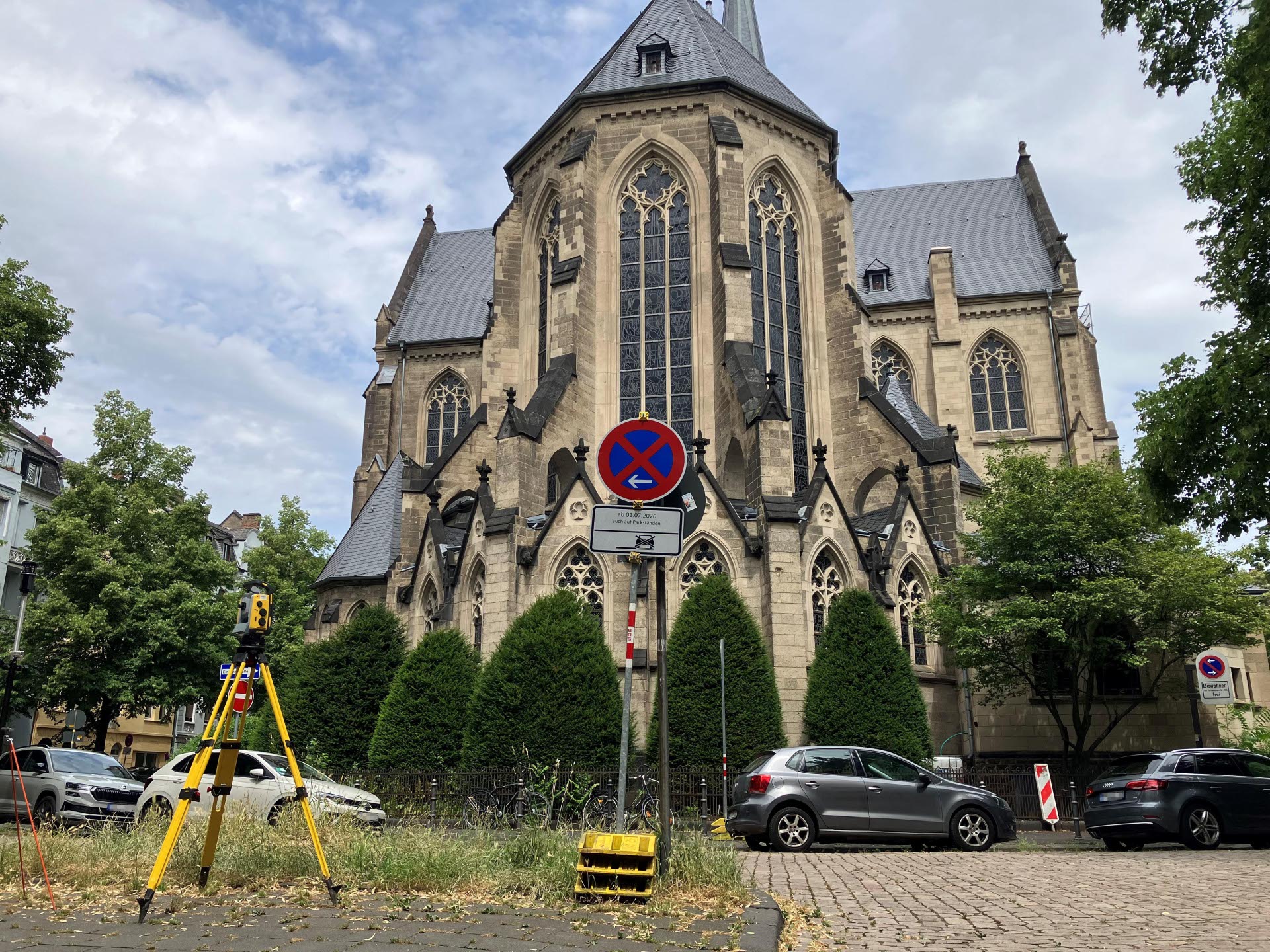 Autos stehen auf einer Straße vor einer Kirche.