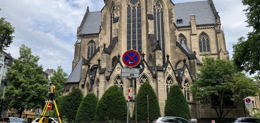 Autos stehen auf einer Straße vor einer Kirche.
