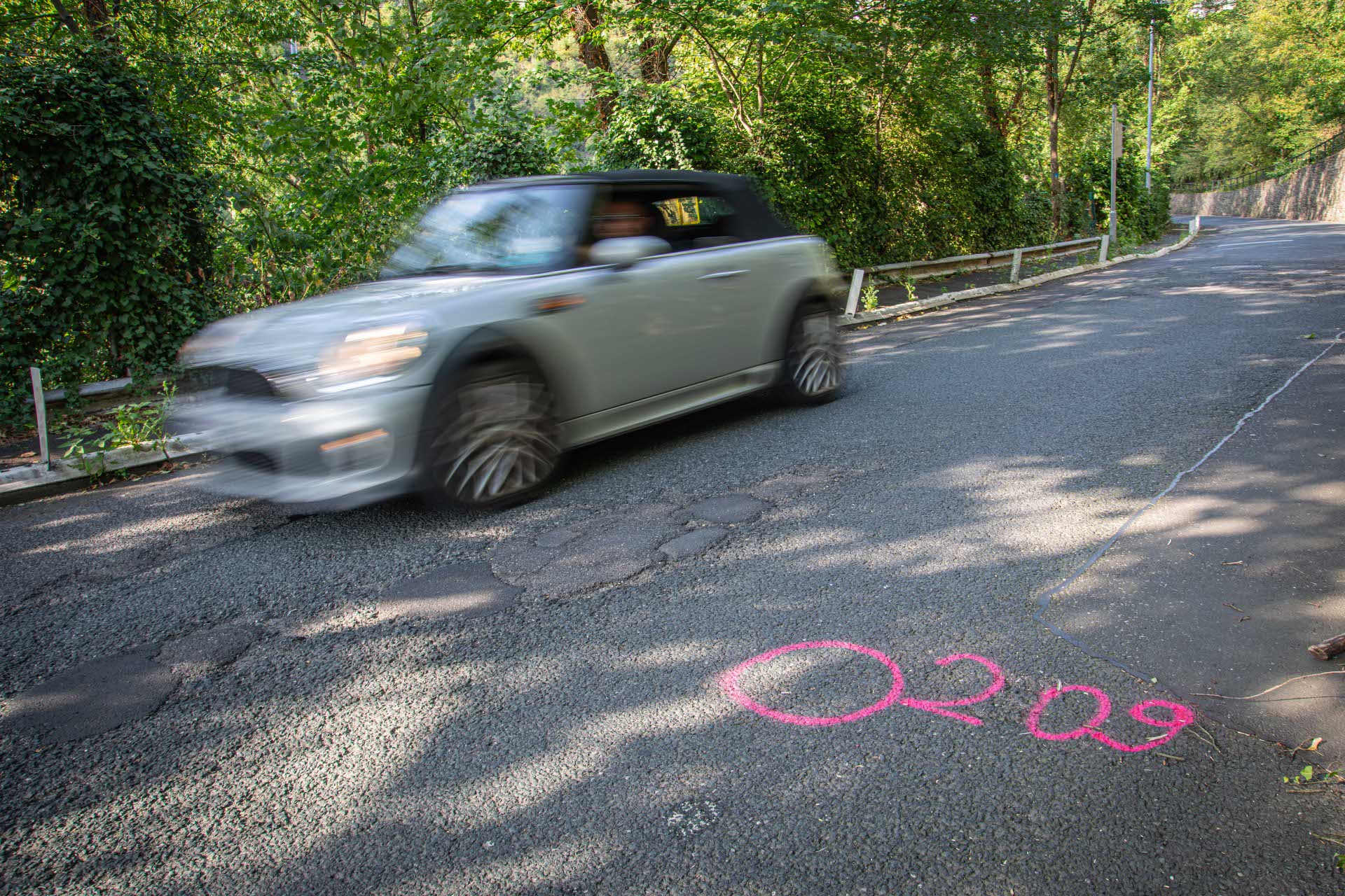Ein Auto fährt über eine kaputte Straße. Ein Auto fährt über eine kaputte Straße.