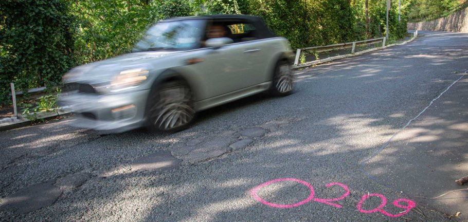 Ein Auto fährt über eine kaputte Straße. Ein Auto fährt über eine kaputte Straße.