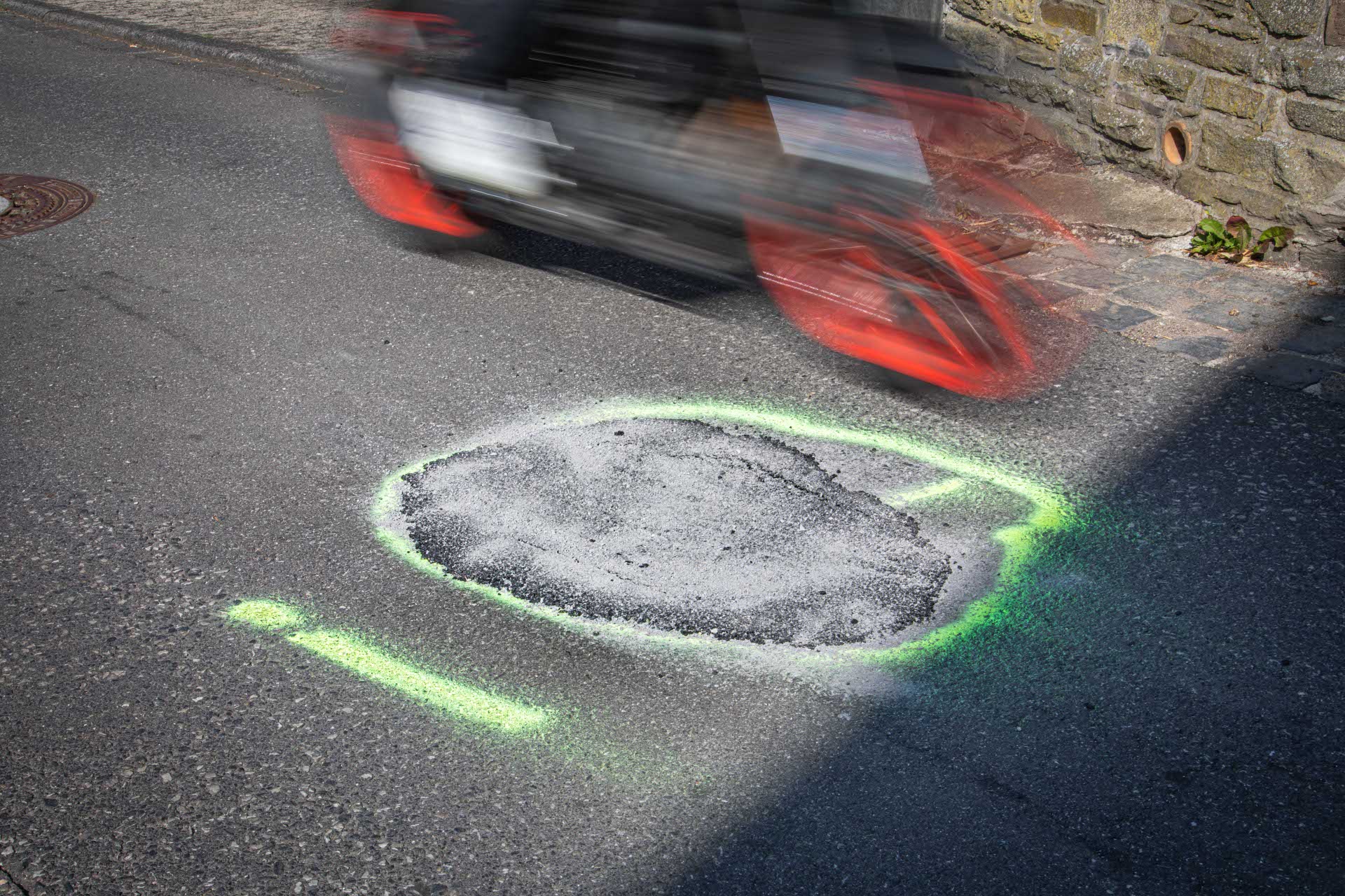 Ein Motorrad fährt an einem Markierung auf der Fahrbahn vorbei. Ein Motorrad fährt an einem Markierung auf der Fahrbahn vorbei.