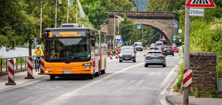 Ein Bus und Autos fahren auf einer Straße.