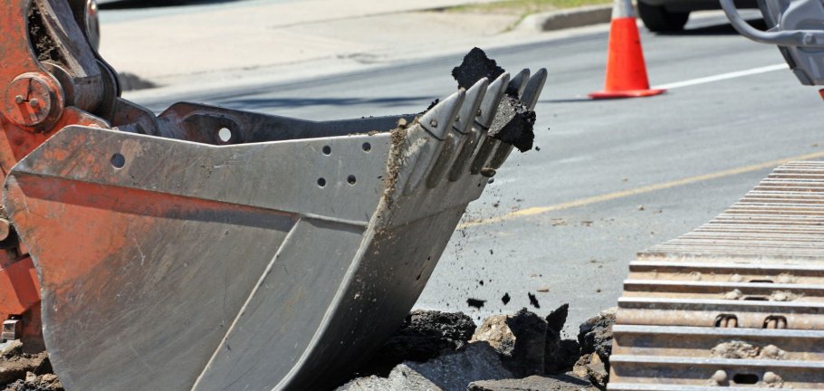 Beispielbild: Bagger durchbricht Asphaltschicht
