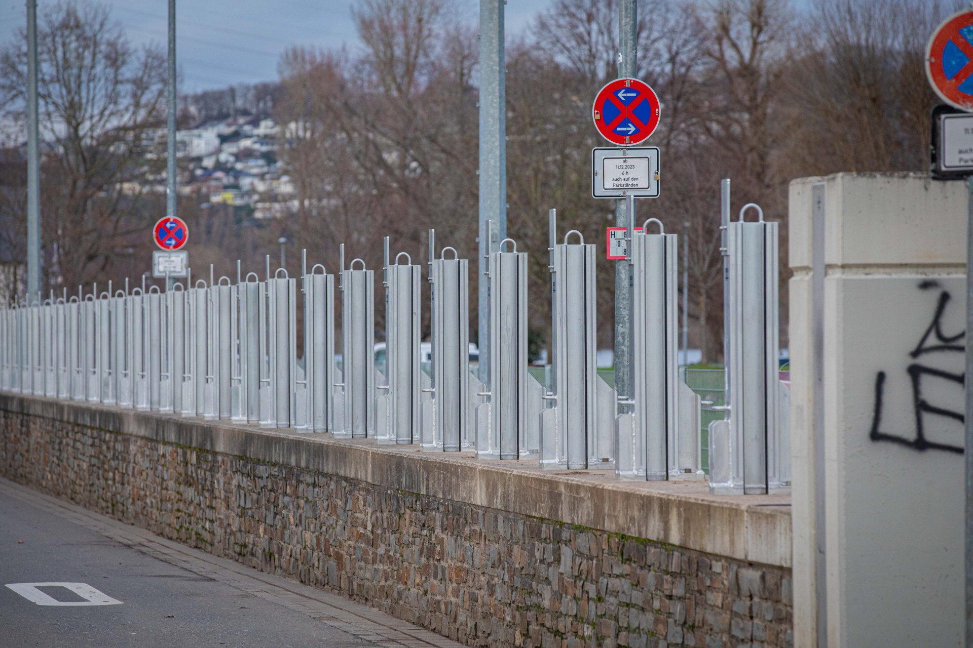 Metallstützen stehen auf einer Mauer.