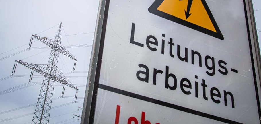 Stromleitungen sind hinter einem Hinweisschild zu sehen. Stromleitungen sind hinter einem Hinweisschild zu sehen.