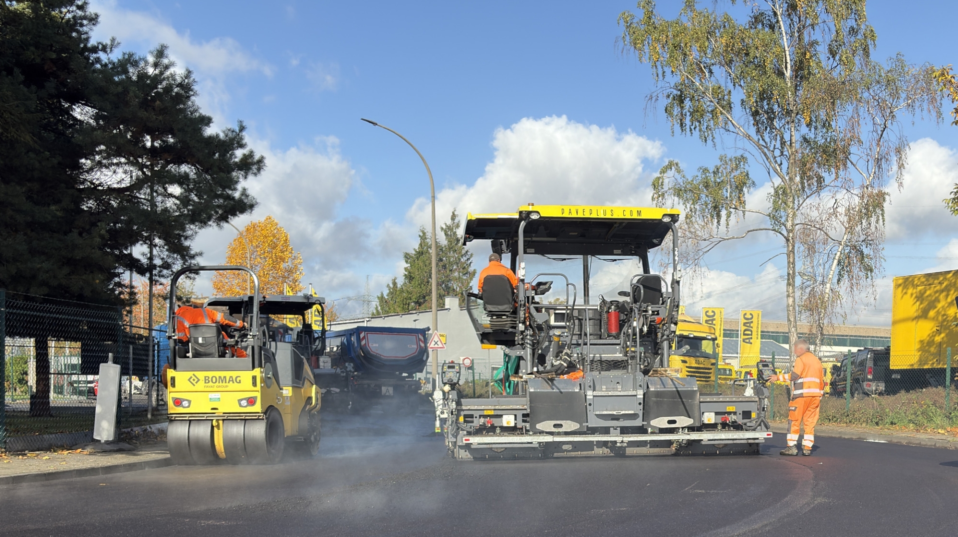 Auf einer Straße wird mit Baumaschinen Asphalt eingebracht. Auf einer Straße wird mit Baumaschinen Asphalt eingebracht.